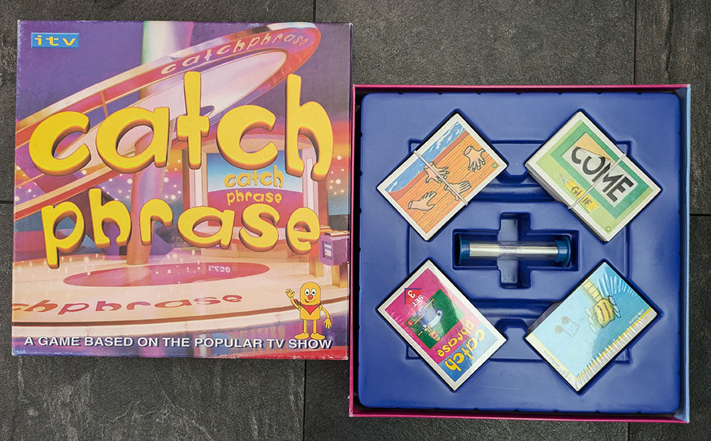 Complete Catch Phrase Board Game (2005) setup with game board, phrase cards, and playing pieces ready for family-friendly gameplay.
