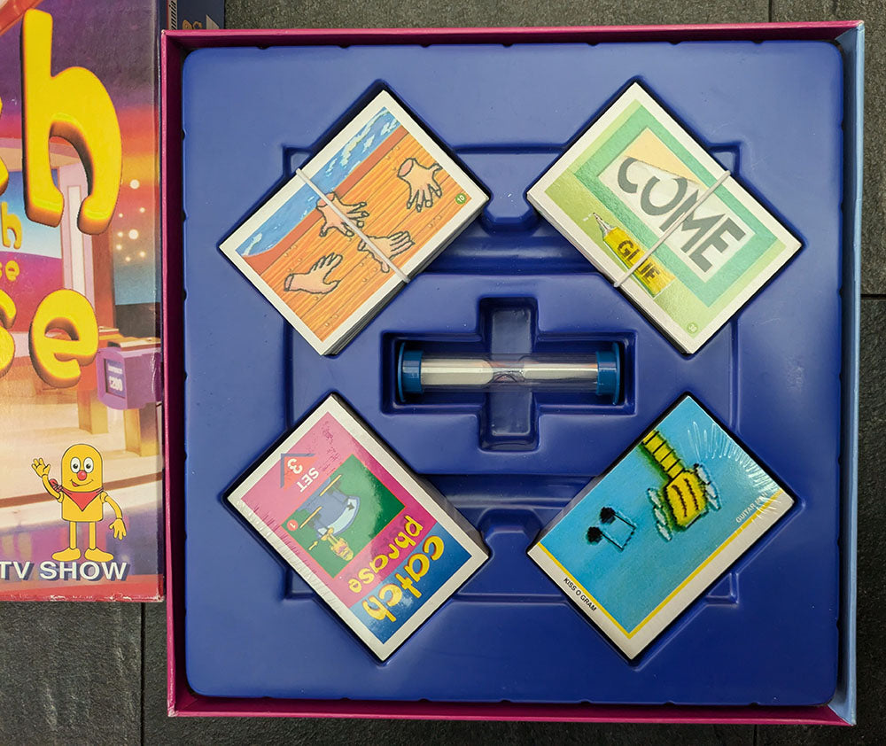 Complete Catch Phrase Board Game (2005) setup with game board, phrase cards, and playing pieces ready for family-friendly gameplay.