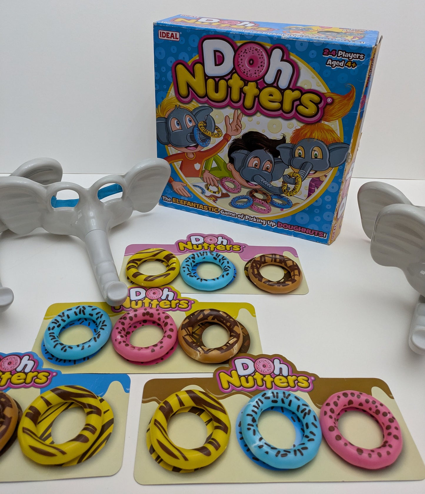 "Complete Doh Nutters game setup with elephant masks, plastic doughnuts, and game board ready for fun-filled, action-packed family play."