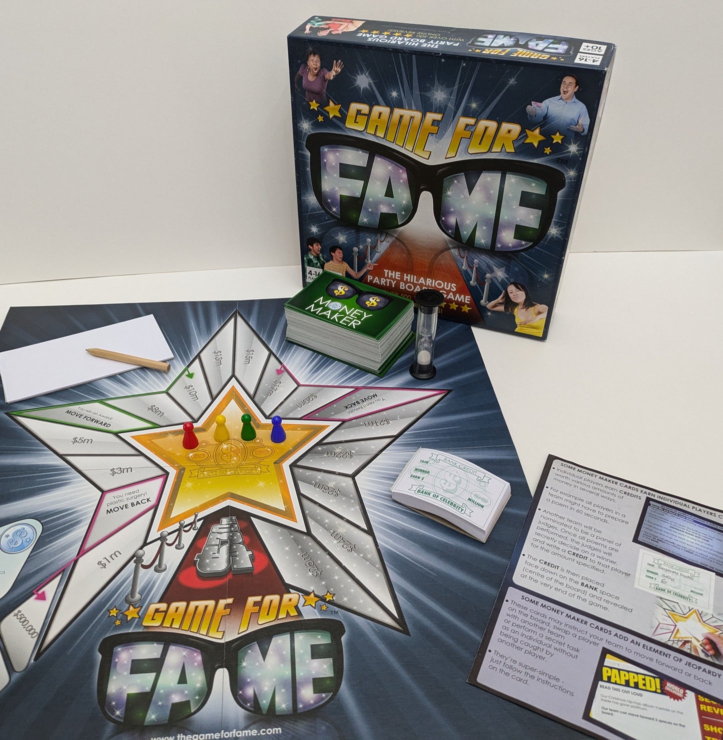 "Complete Game for Fame (2010) game setup with cards, money tokens, and challenge boards ready for a hilarious and competitive party experience."