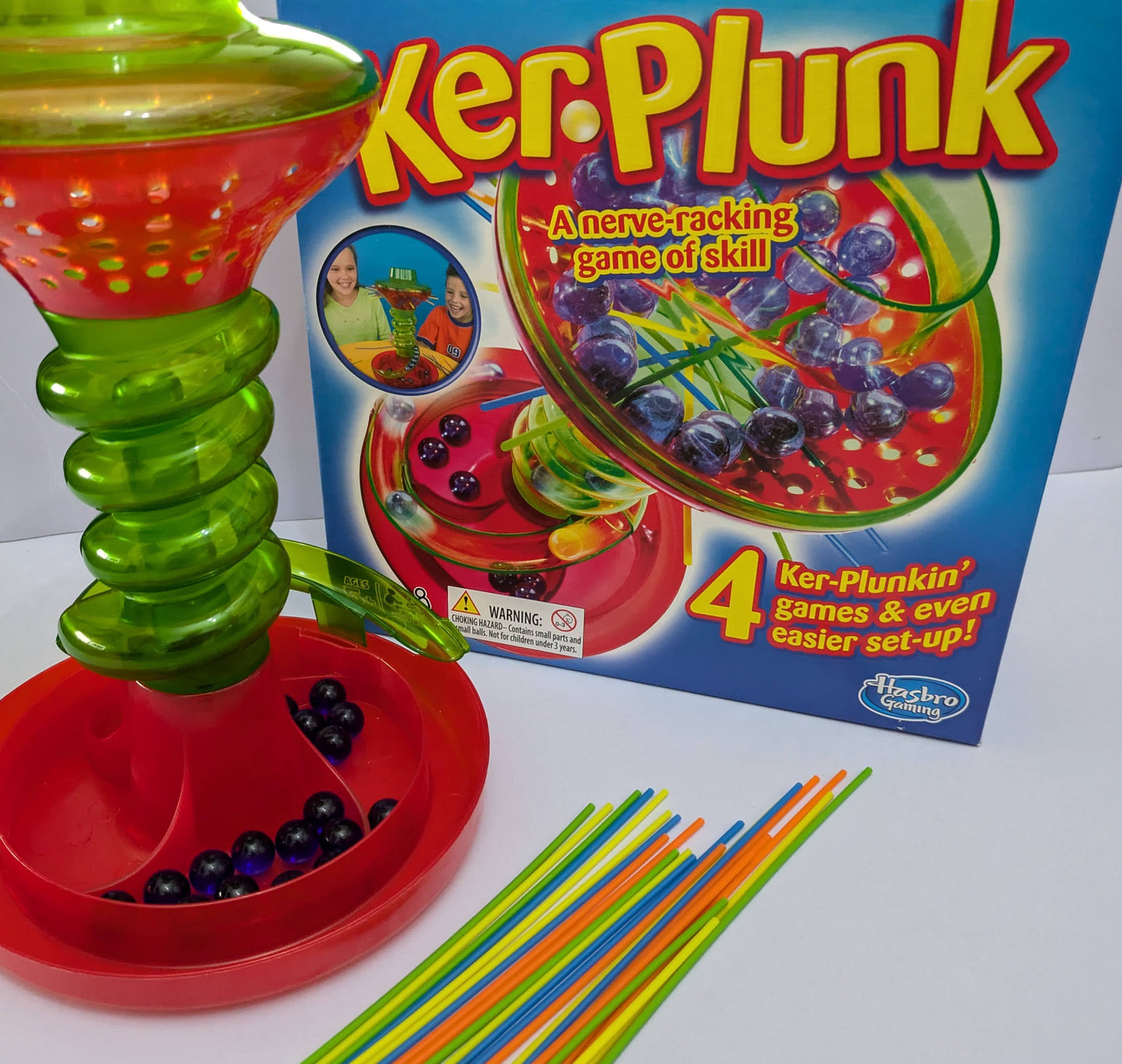 Complete KerPlunk (2013) game setup with cylinder, sticks, and marbles ready for an exciting and suspenseful family game night.