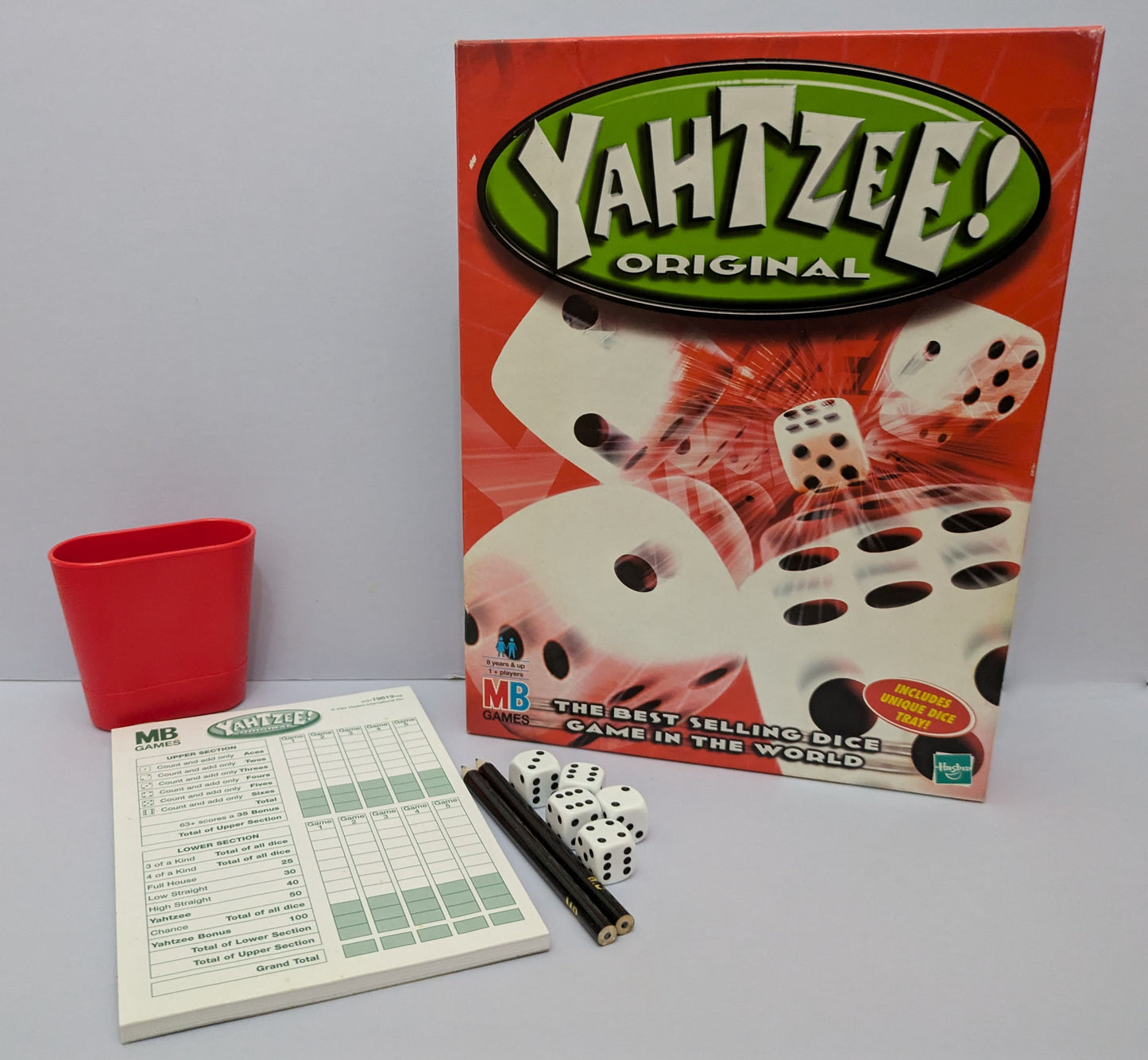 "Complete Yahtzee game setup with dice, scorecards, and a dice cup ready for exciting dice-rolling action."