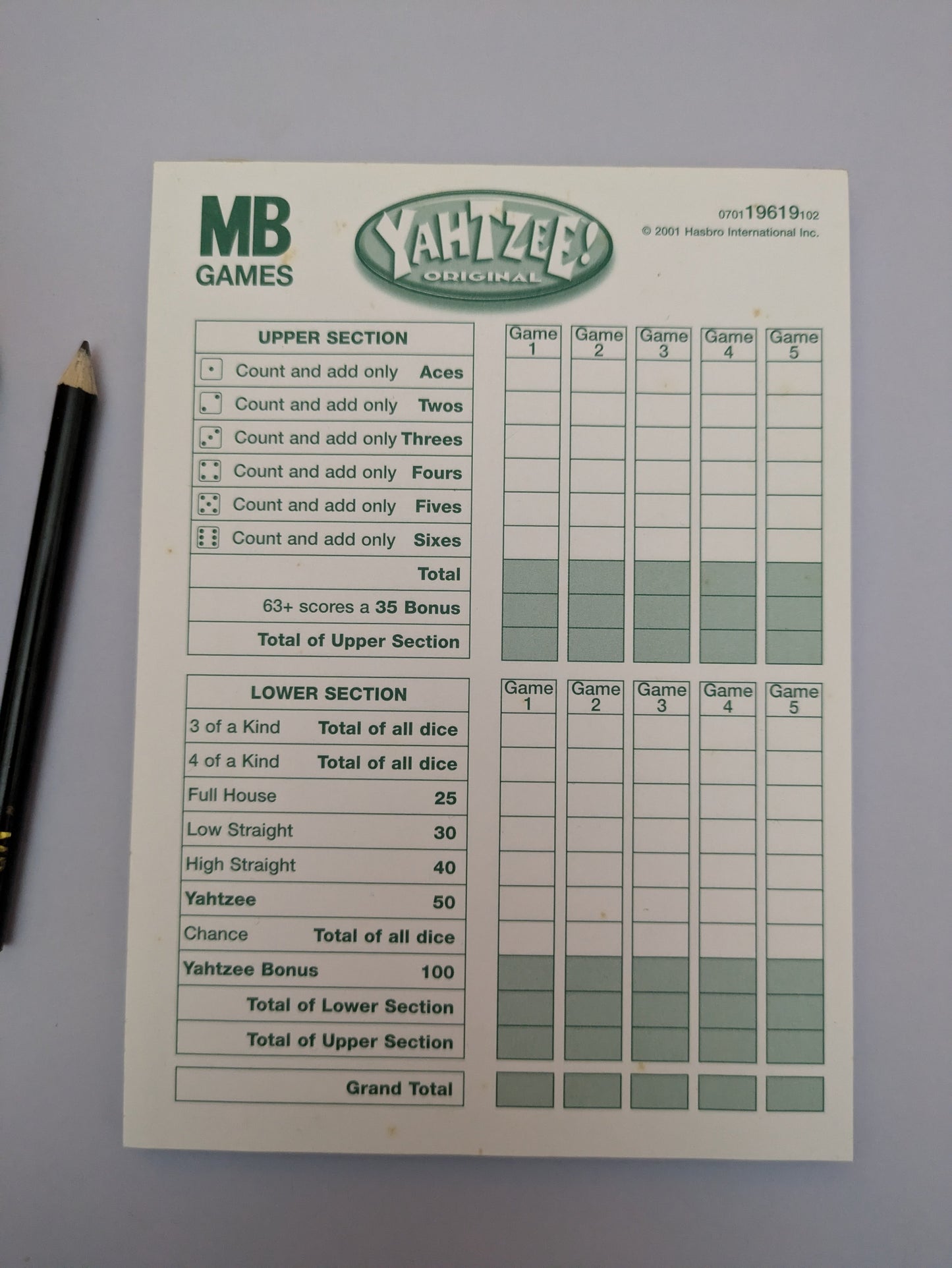 "Complete Yahtzee game setup with dice, scorecards, and a dice cup ready for exciting dice-rolling action."