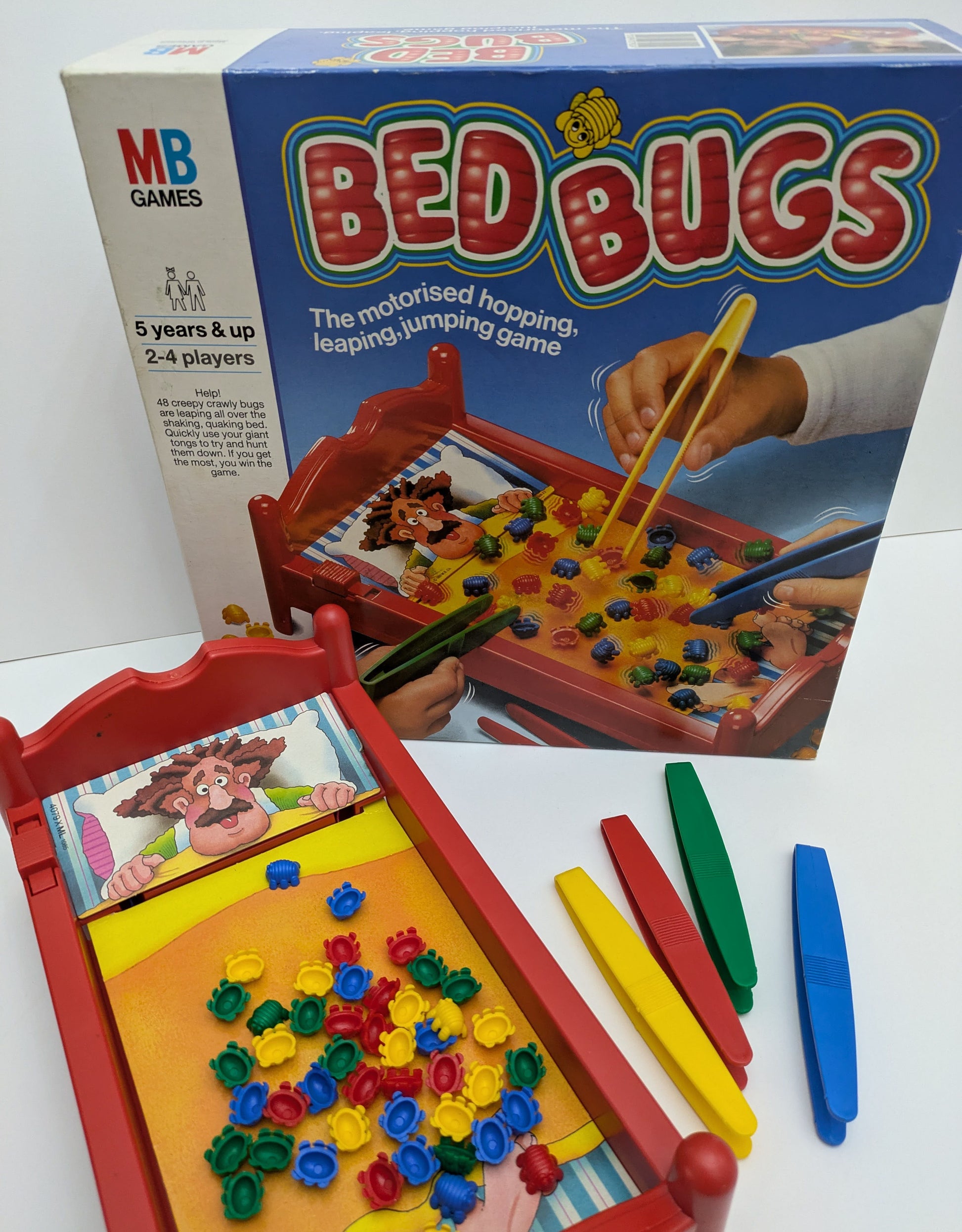"Complete Bed Bugs (1985) game setup with plastic bugs, tweezers, and a vibrating game bed ready for a fast-paced bug-catching race."