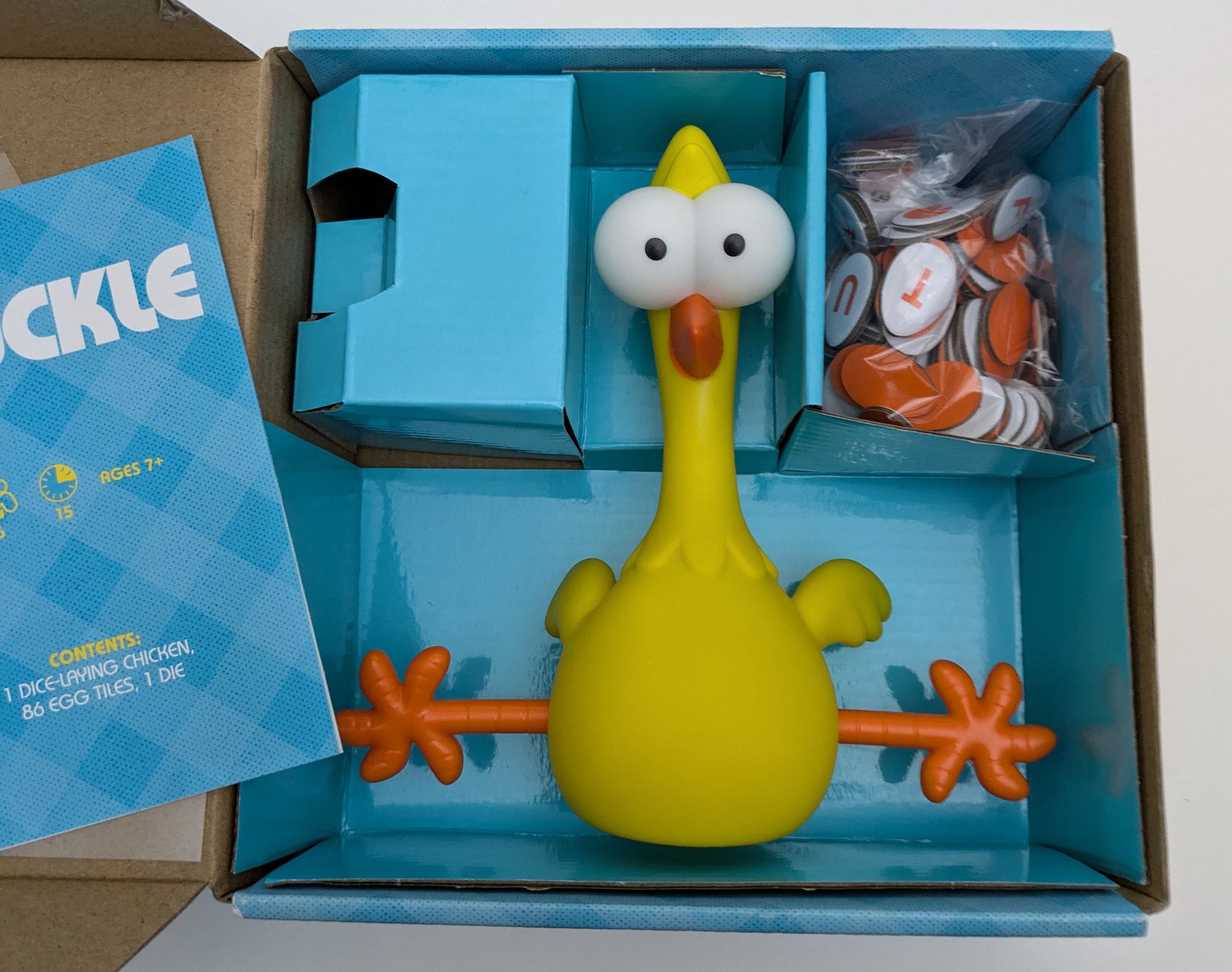 "Cluckle (2021) game box featuring a rubber chicken, egg tiles, and colourful game graphics highlighting the fun, fast-paced word challenge."