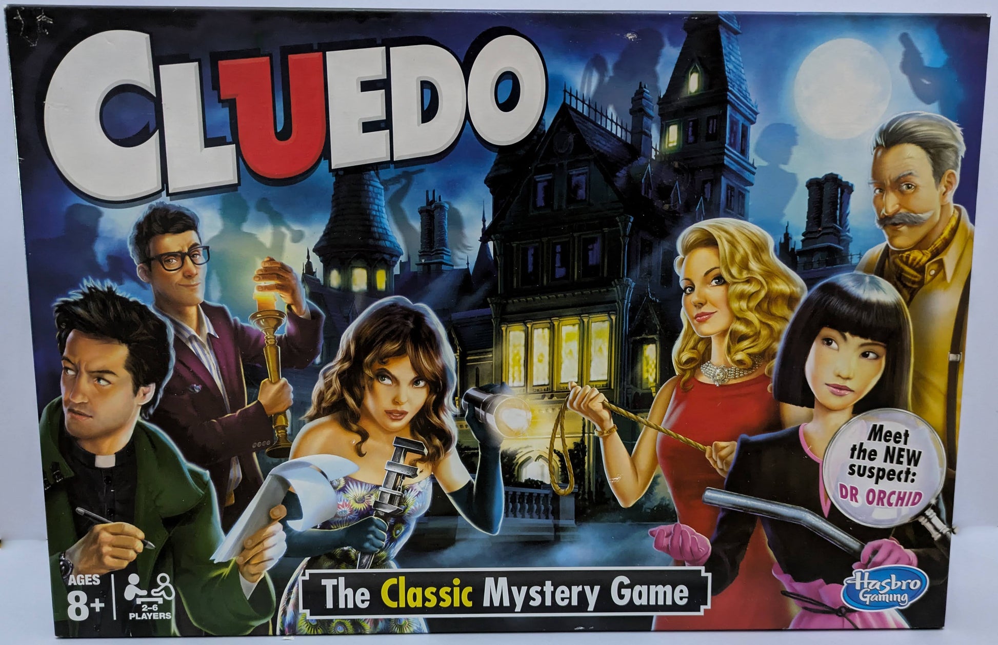 Cluedo (2012) game box featuring iconic suspects, weapons, and mansion visuals with the game logo highlighting classic mystery gameplay.