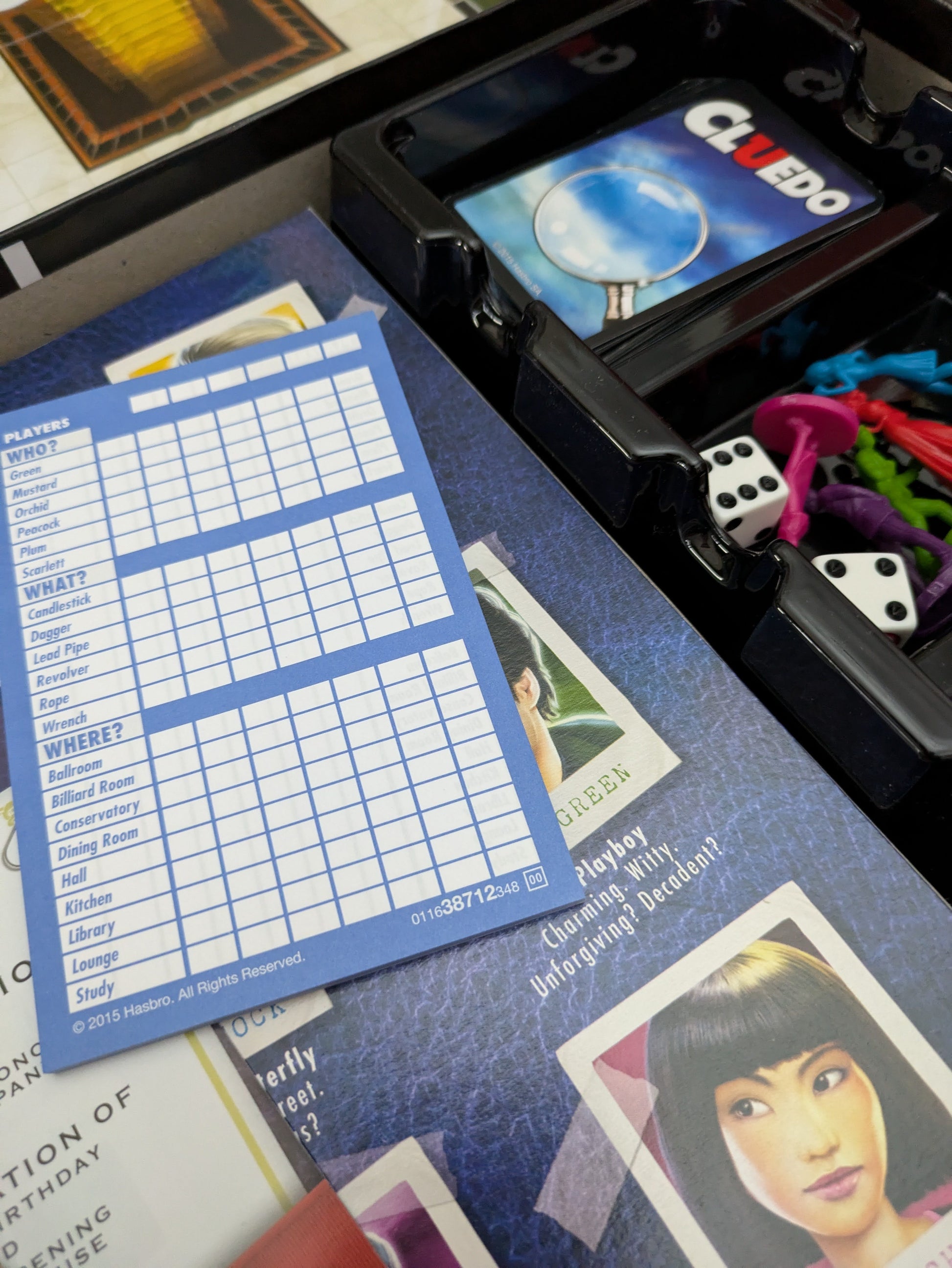 Complete setup of Cluedo (2012) with board, suspect cards, weapon tokens, and player pieces ready for a thrilling mystery game night.