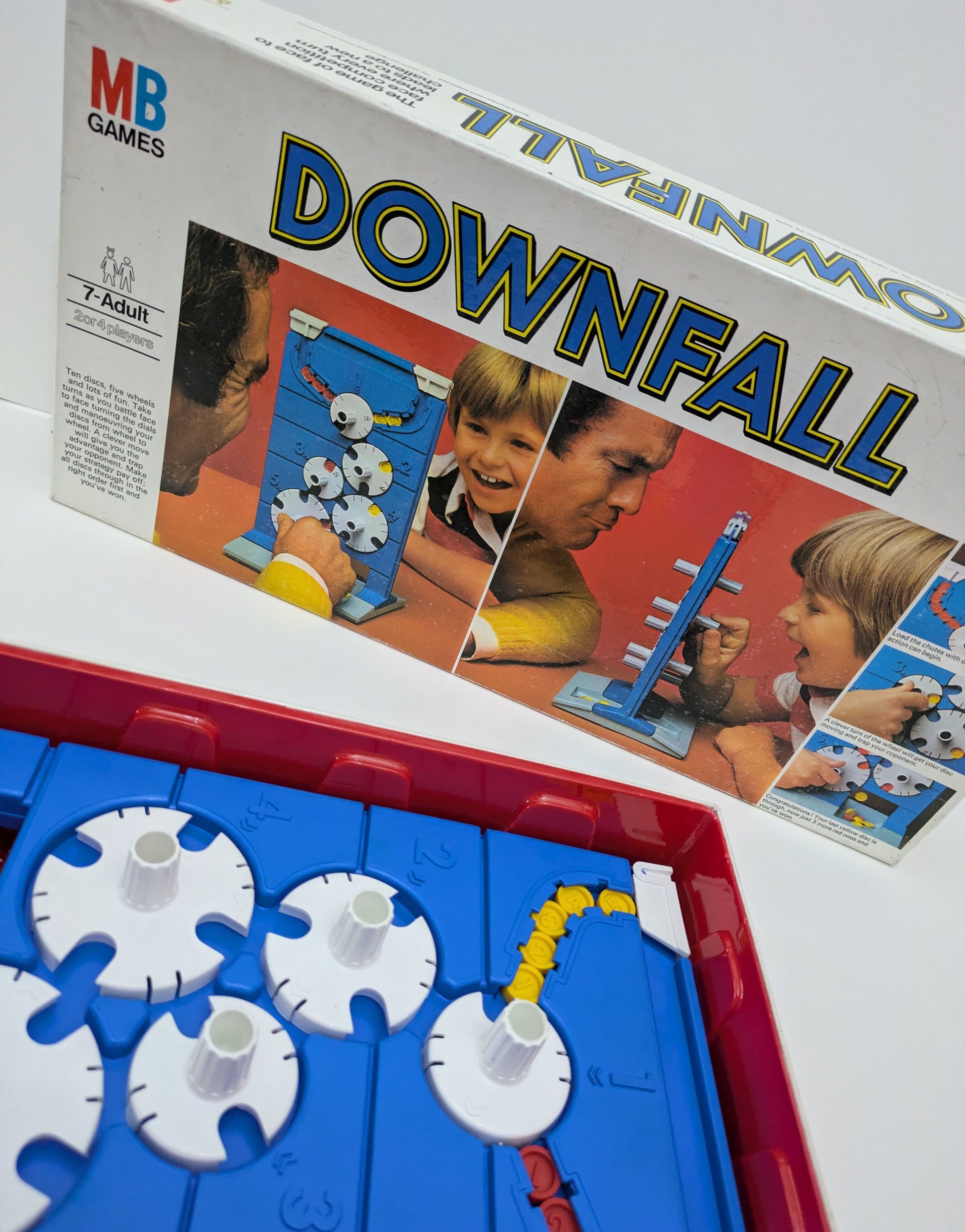 "Downfall game box featuring rotating dials and discs, highlighting the strategy-driven gameplay for two players."