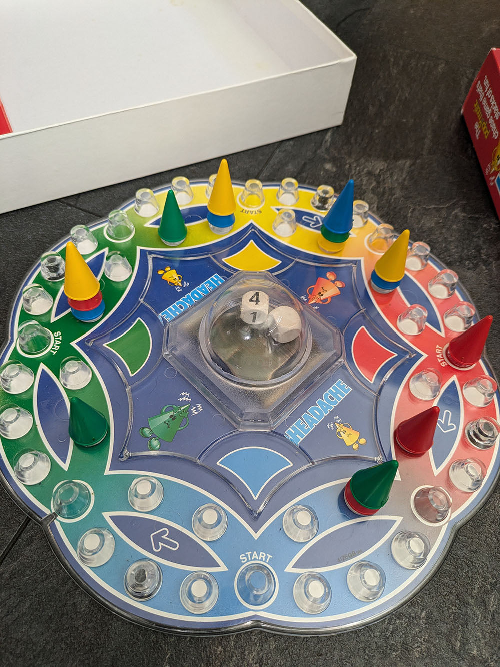 "Complete Headache game setup with game board, colourful cone pieces, and player tokens ready for strategic cone-stacking competition."