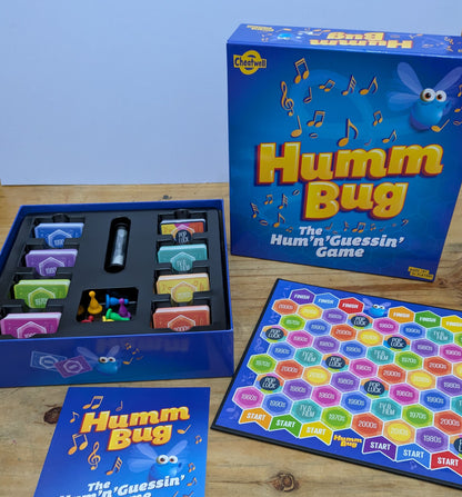 "Humm Bug (2020) game box featuring musical notes, fun party-themed graphics, and a game logo highlighting musical guessing fun."