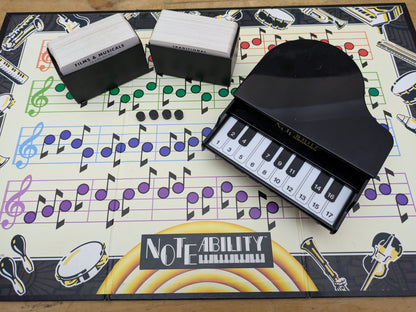 "Complete Noteability (1990) game setup with electronic piano, song cards, and scoring board ready for a fun musical guessing game night."