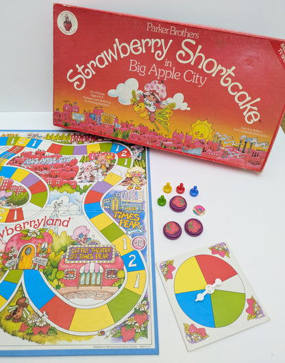 Strawberry Shortcake in Big Apple City game box featuring colourful characters, a whimsical game board, and the game logo highlighting nostalgic gameplay.